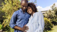 Pregnant person and partner embracing