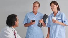 Hospital staff, with one holding the Ascom Myco 4,  in a conversation
