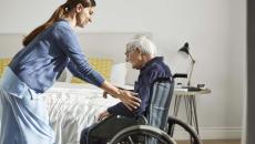 Healthcare worker assisting patient in wheelchair