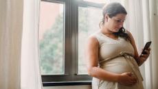 A pregnant person texting