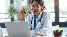 Doctor waving at laptop screen