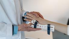 A doctor fitting a wrist brace on a patient